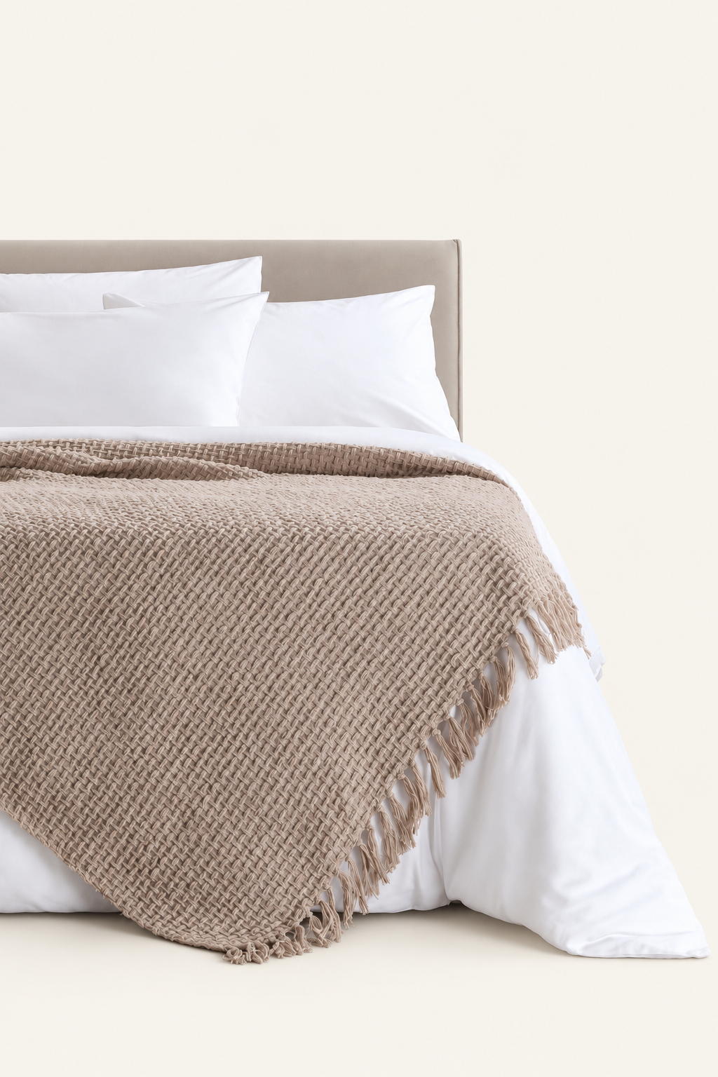 Devina Beige throw — displayed on a bed against a light beige background