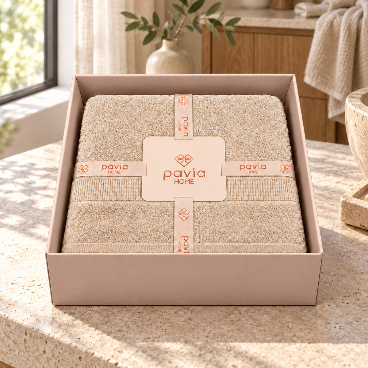 Luan beige towel set in a Pavia Home gift box beside a bright bathroom window
