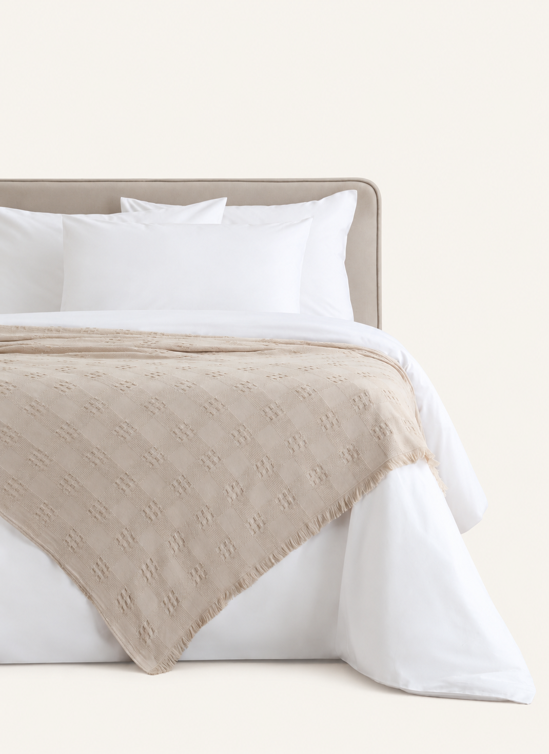 Danna Beige bedspread displayed on a bed against a light beige background