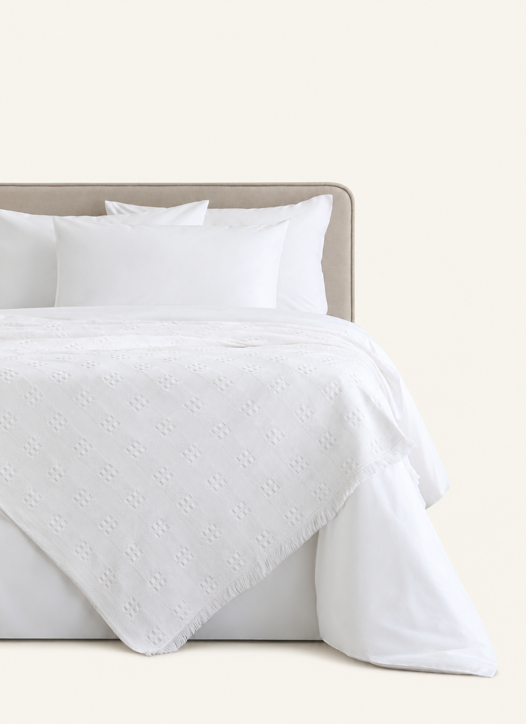 Danna White bedspread displayed on a bed against a light beige background