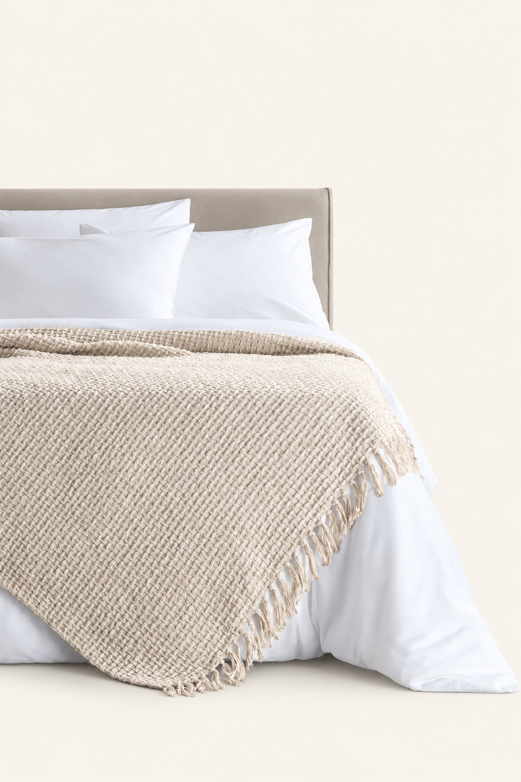 Devina Ecru throw — displayed on a bed against a light beige background