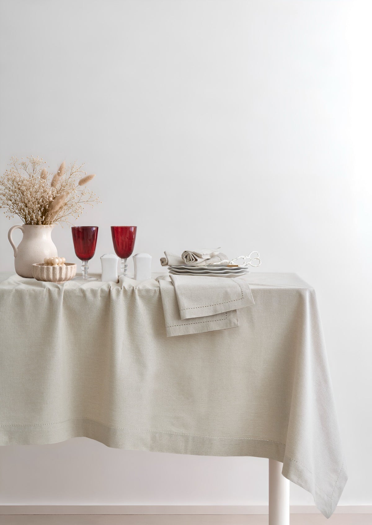Jolly Light Beige tablecloth styled on a dining table with ceramics and glassware