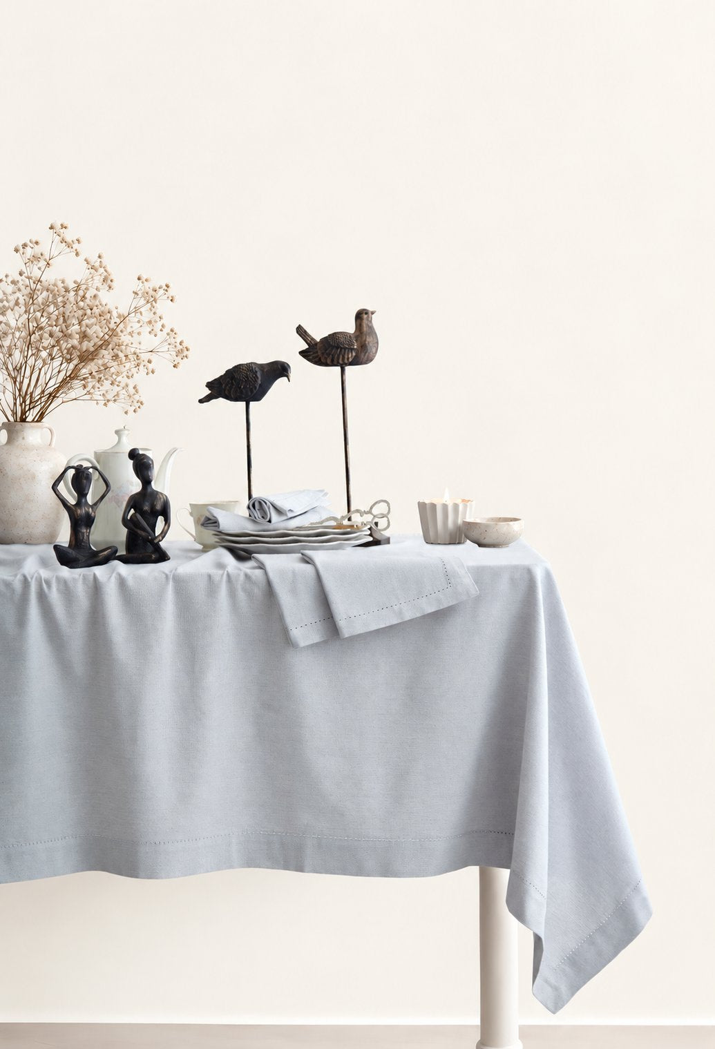 Jolly Light Grey tablecloth styled on a dining table with decorative objects